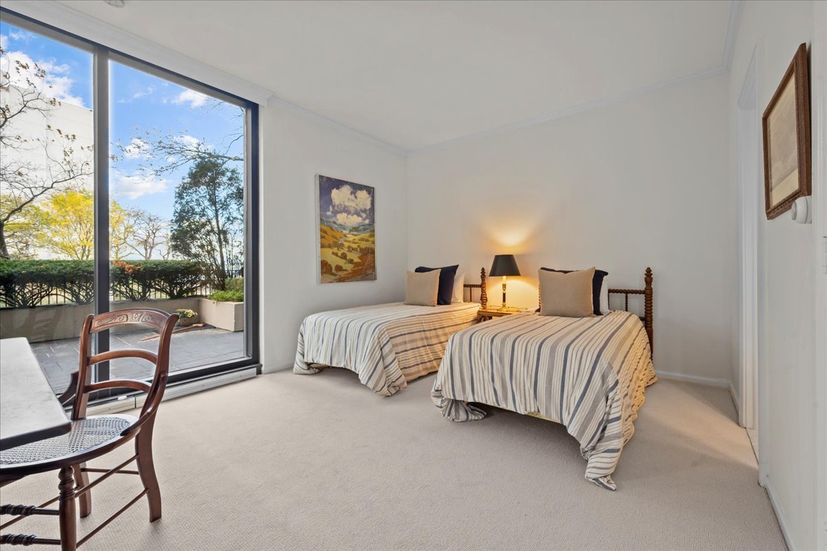 1420 Sheridan Road, Unit 1H Wilmette, IL 60091 - Photo 25 of 40 a bedroom with a bed and a flat tv screen on dresser