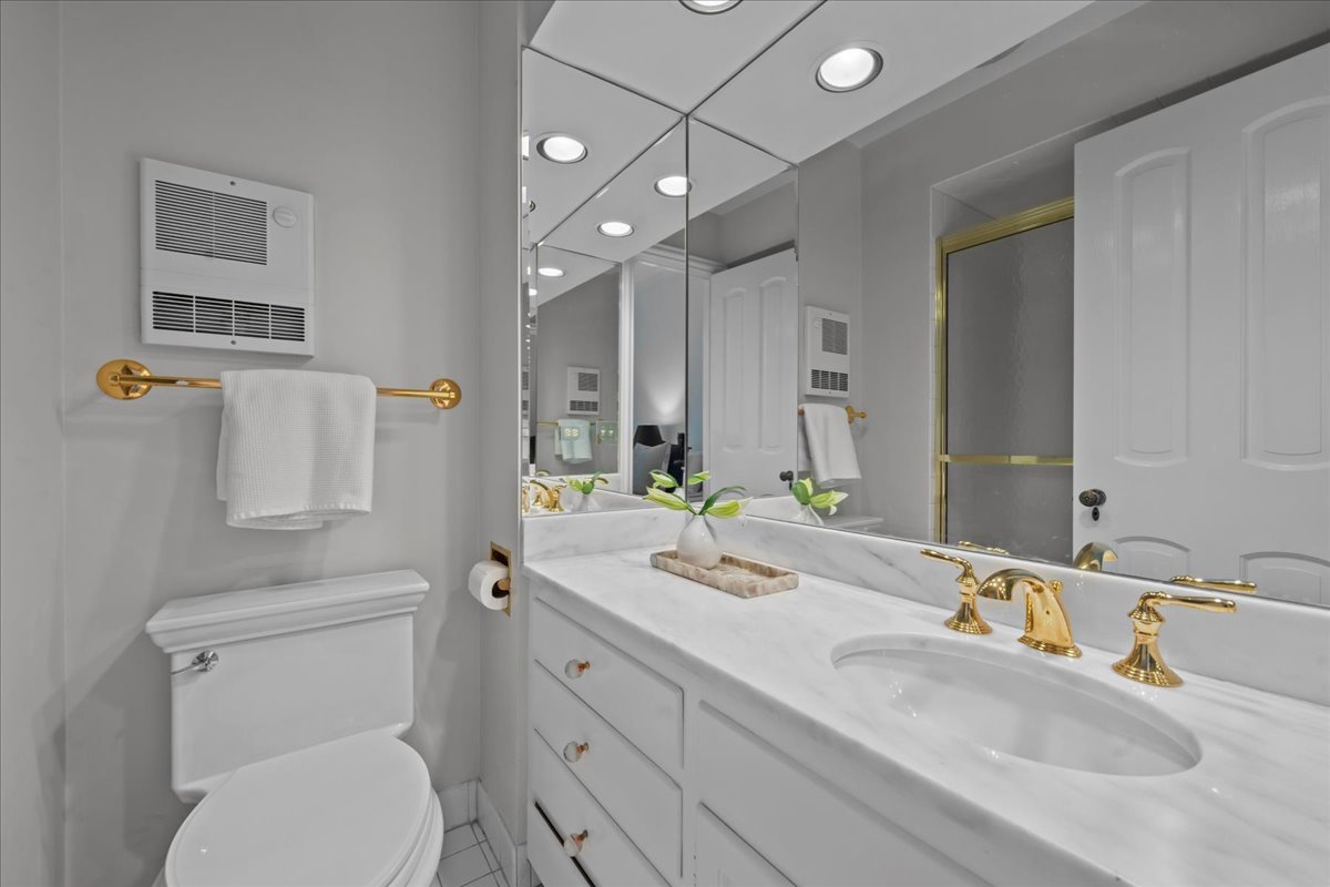 1420 Sheridan Road, Unit 1H Wilmette, IL 60091 - Photo 26 of 40 a bathroom with a granite countertop toilet sink and mirror