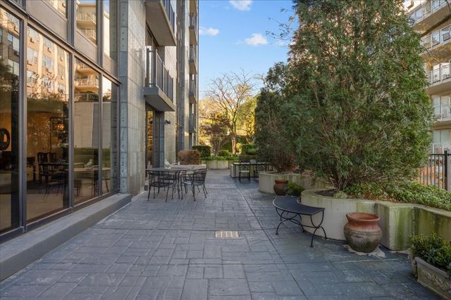 a view of a patio with couches and chairs under an umbrella
