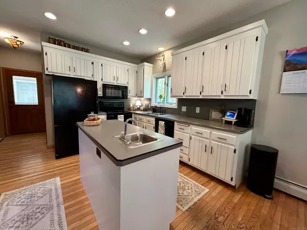 a kitchen with a refrigerator a stove top oven a sink and cabinets