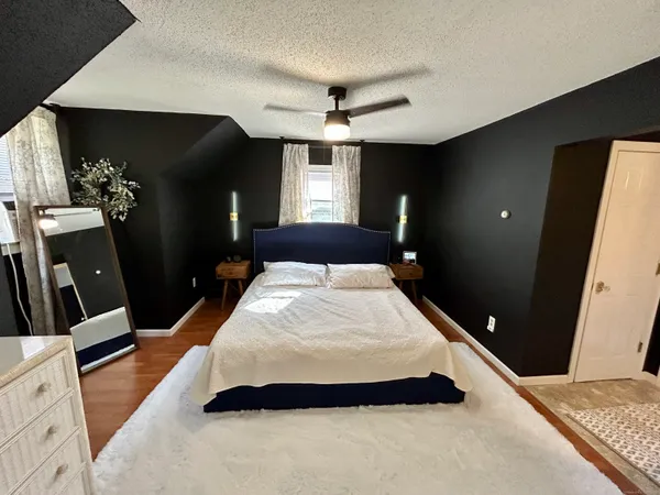a large bed sitting in a bedroom and a flat tv screen