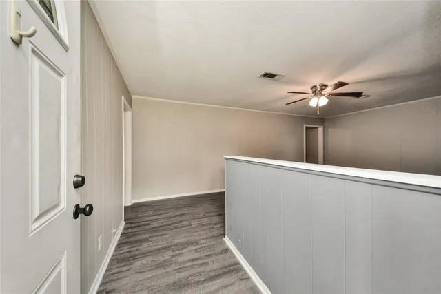 a view of a hallway with wooden floor and chandelier