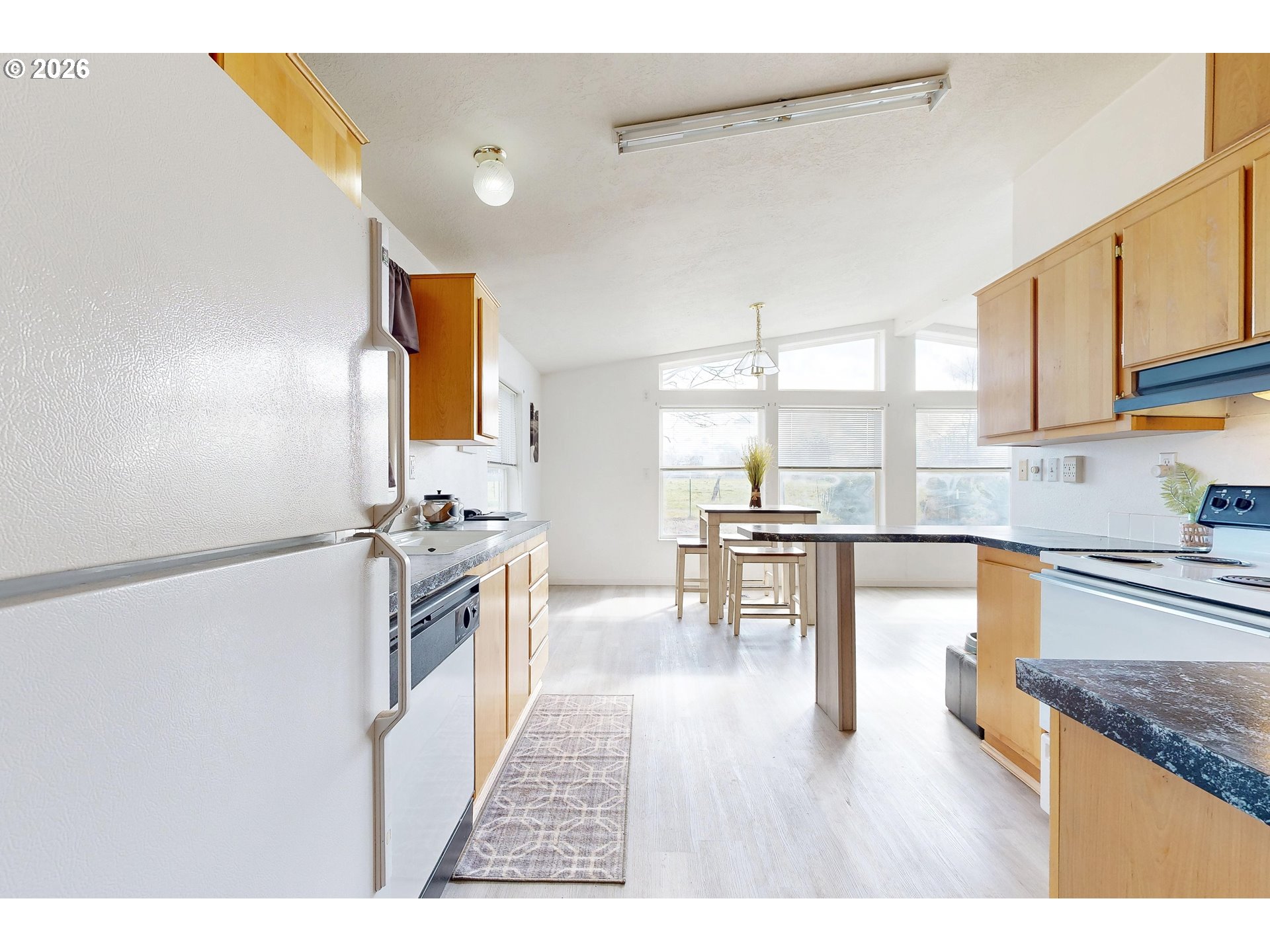 84889 Triangle Station Road Milton Freewater, OR 97862 - Photo 15 of 40 a kitchen with granite countertop a stove top oven a sink a dining table and chairs