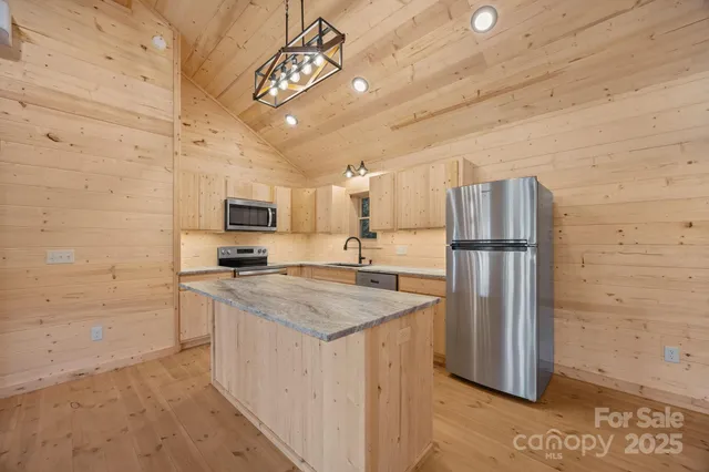 a kitchen with stainless steel appliances granite countertop a sink a refrigerator and a stove