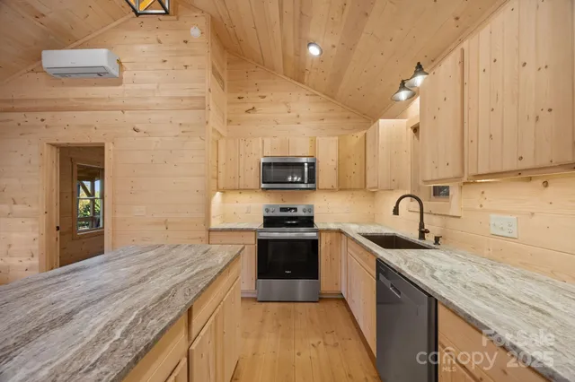 a kitchen with stainless steel appliances granite countertop wooden cabinets a stove top oven a sink and dishwasher