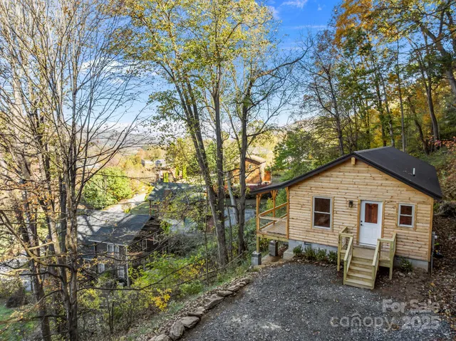 a view of a white house with a yard and sitting area