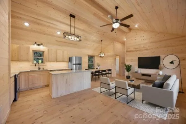 a living room with furniture a flat screen tv and kitchen view