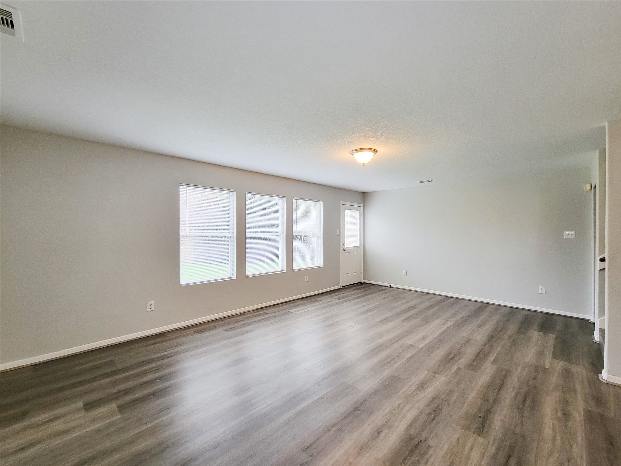 3602 Zephyr Glen Way Houston, TX 77084 - Photo 14 of 42 an empty room with wooden floor and windows