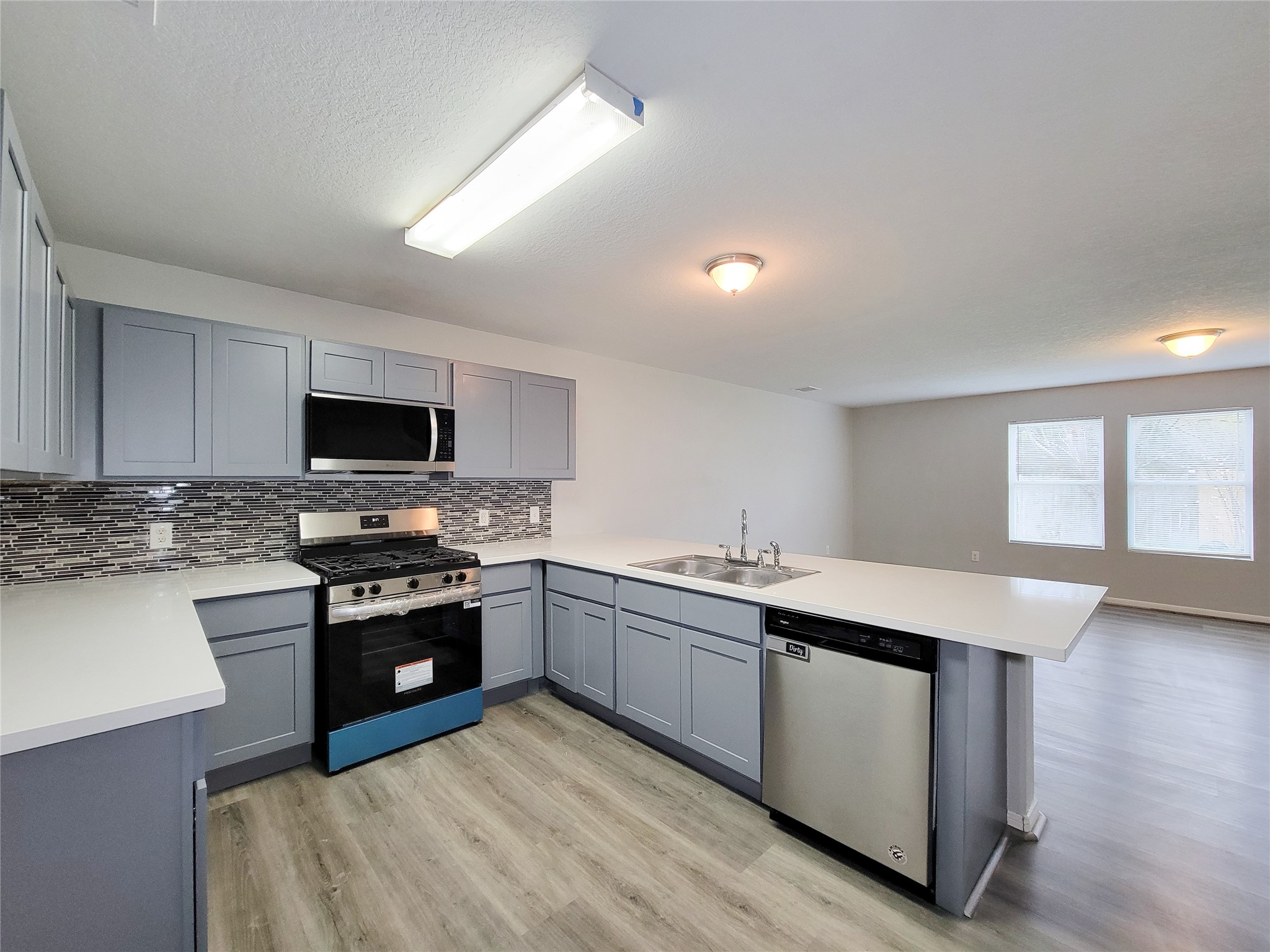 3602 Zephyr Glen Way Houston, TX 77084 - Photo 7 of 42 a kitchen with stainless steel appliances granite countertop a stove a sink dishwasher and a microwave oven with wooden floor