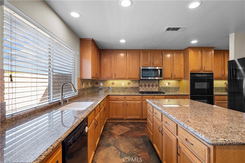 32810 The Old Road Castaic, CA 91384 - Photo 18 of 45 a kitchen with kitchen island granite countertop wooden cabinets a sink and dishwasher