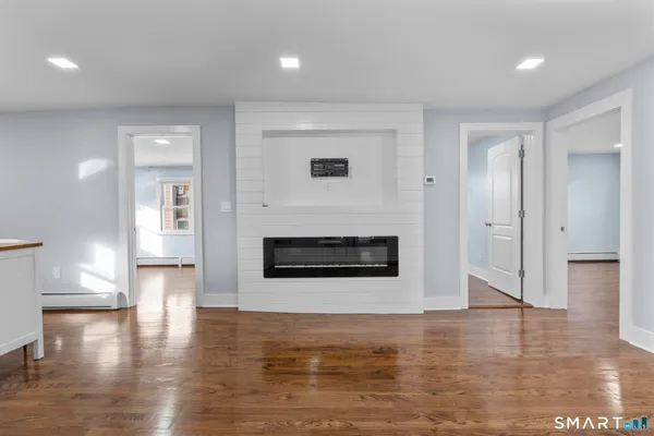 a view of a living room with wooden floor and fire pit