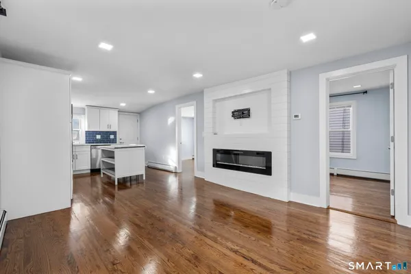 a view of a kitchen with furniture and wooden floor
