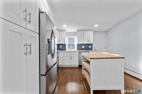 a kitchen with stainless steel appliances a stove refrigerator sink and cabinets