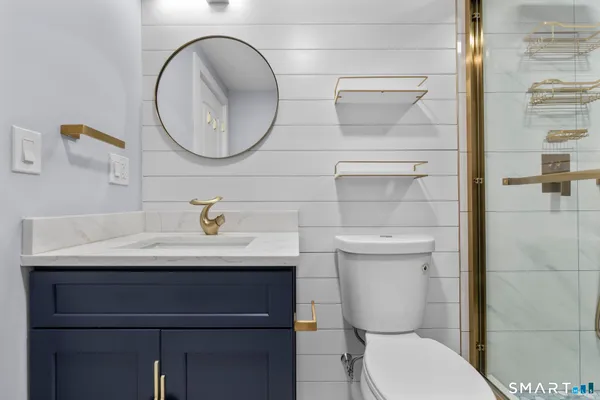 a bathroom with a sink a toilet and a mirror