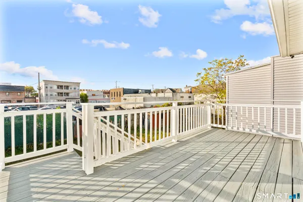 a view of a balcony with wooden floor and city view