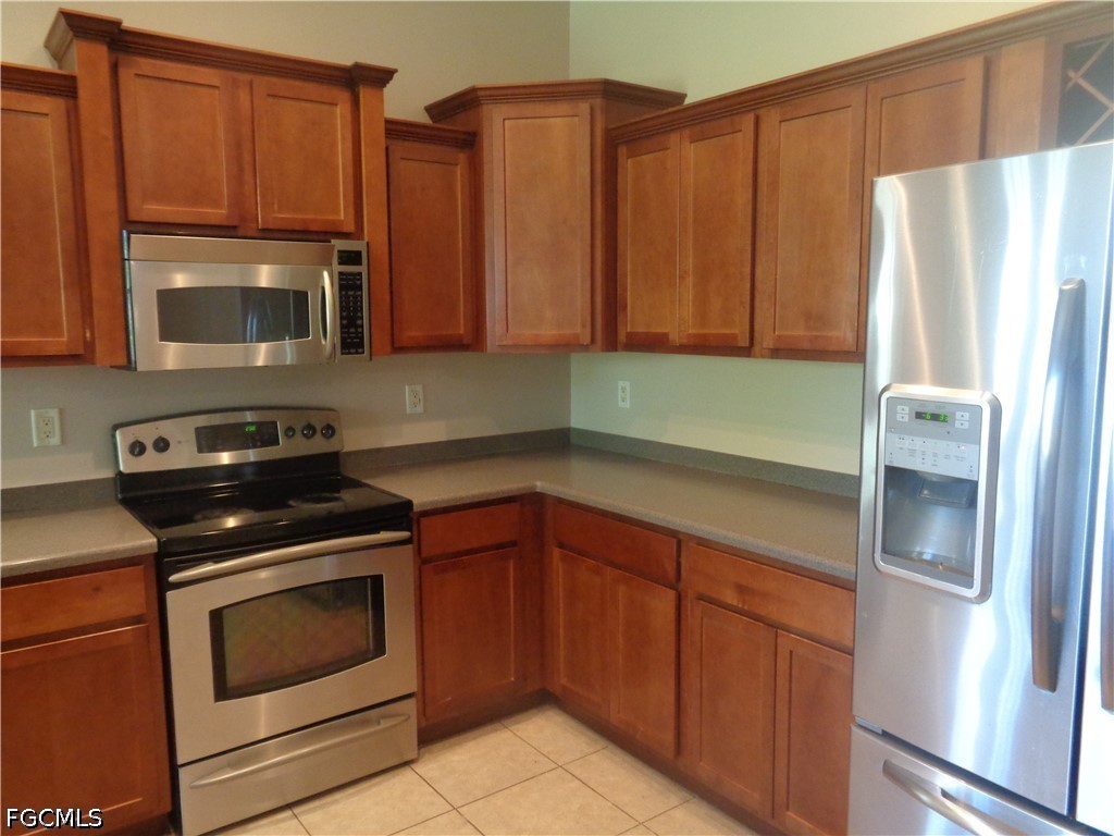 2463 Nature Pointe Loop Fort Myers, FL 33905 - Photo 14 of 50 a kitchen with stainless steel appliances granite countertop a refrigerator stove and microwave
