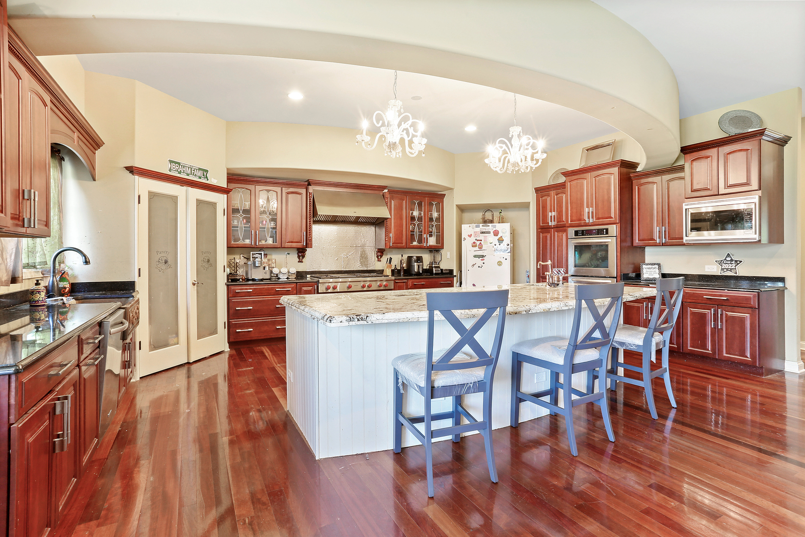 54 Sawgrass Drive Lemont, IL 60439 - Photo 9 of 41 a kitchen with stainless steel appliances kitchen island granite countertop wooden floors and wooden cabinets