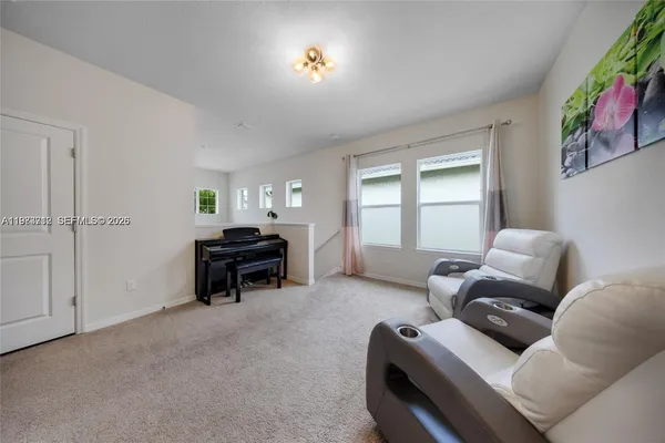 a living room with furniture and a piano