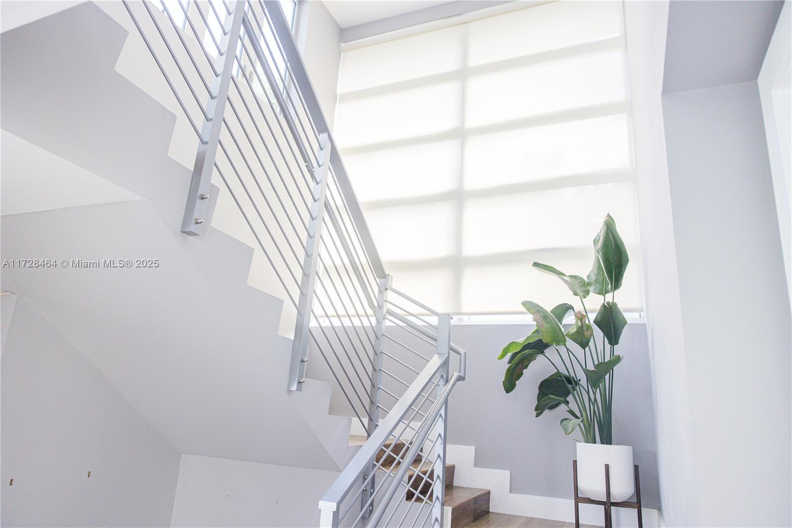 6790 Southwest 72nd Street South Miami, FL 33143 - Photo 22 of 34 a view of staircase with wooden floor and a potted plant