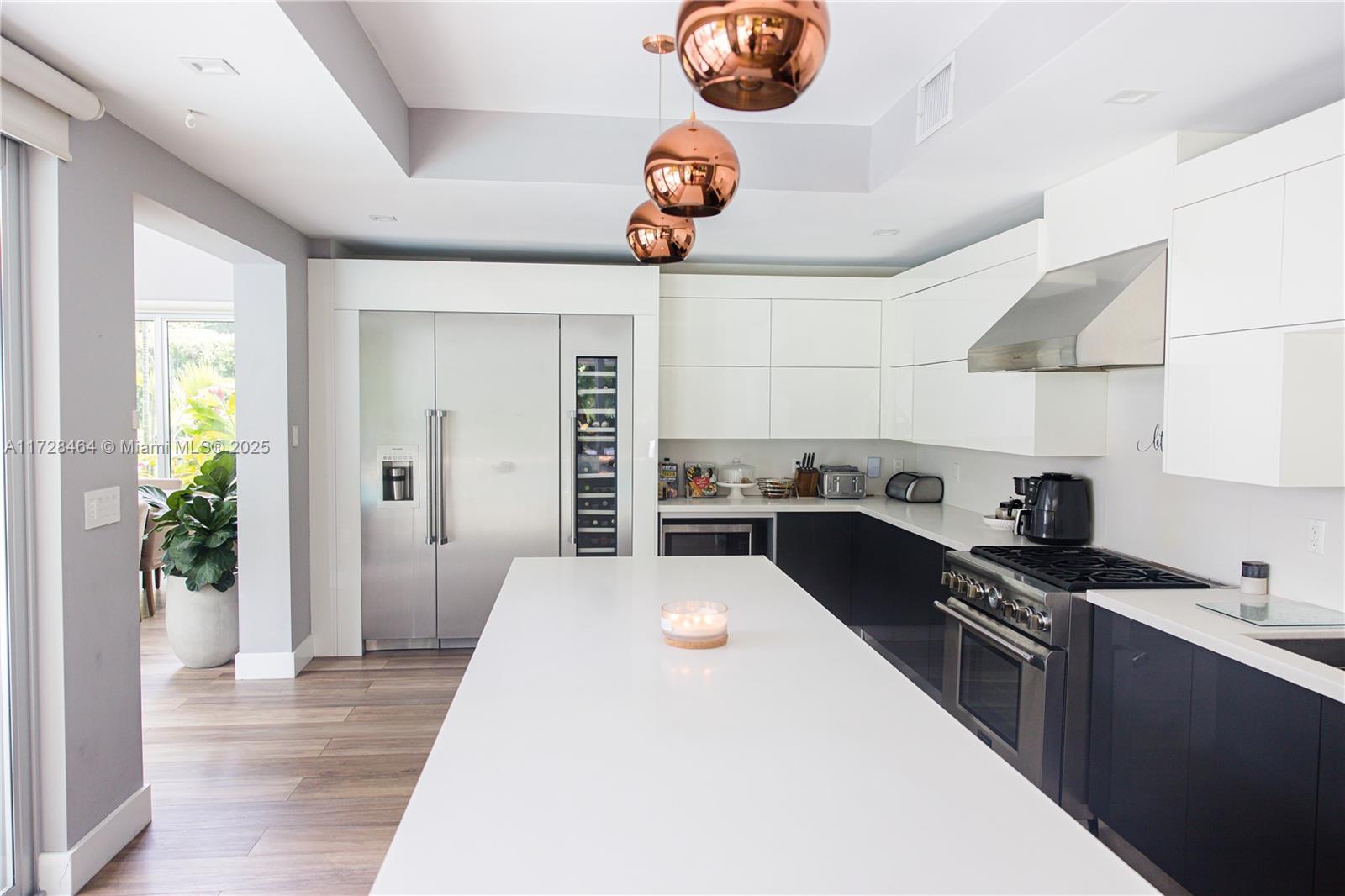 6790 Southwest 72nd Street South Miami, FL 33143 - Photo 8 of 34 a kitchen with stainless steel appliances a stove a chimney a sink and white cabinets