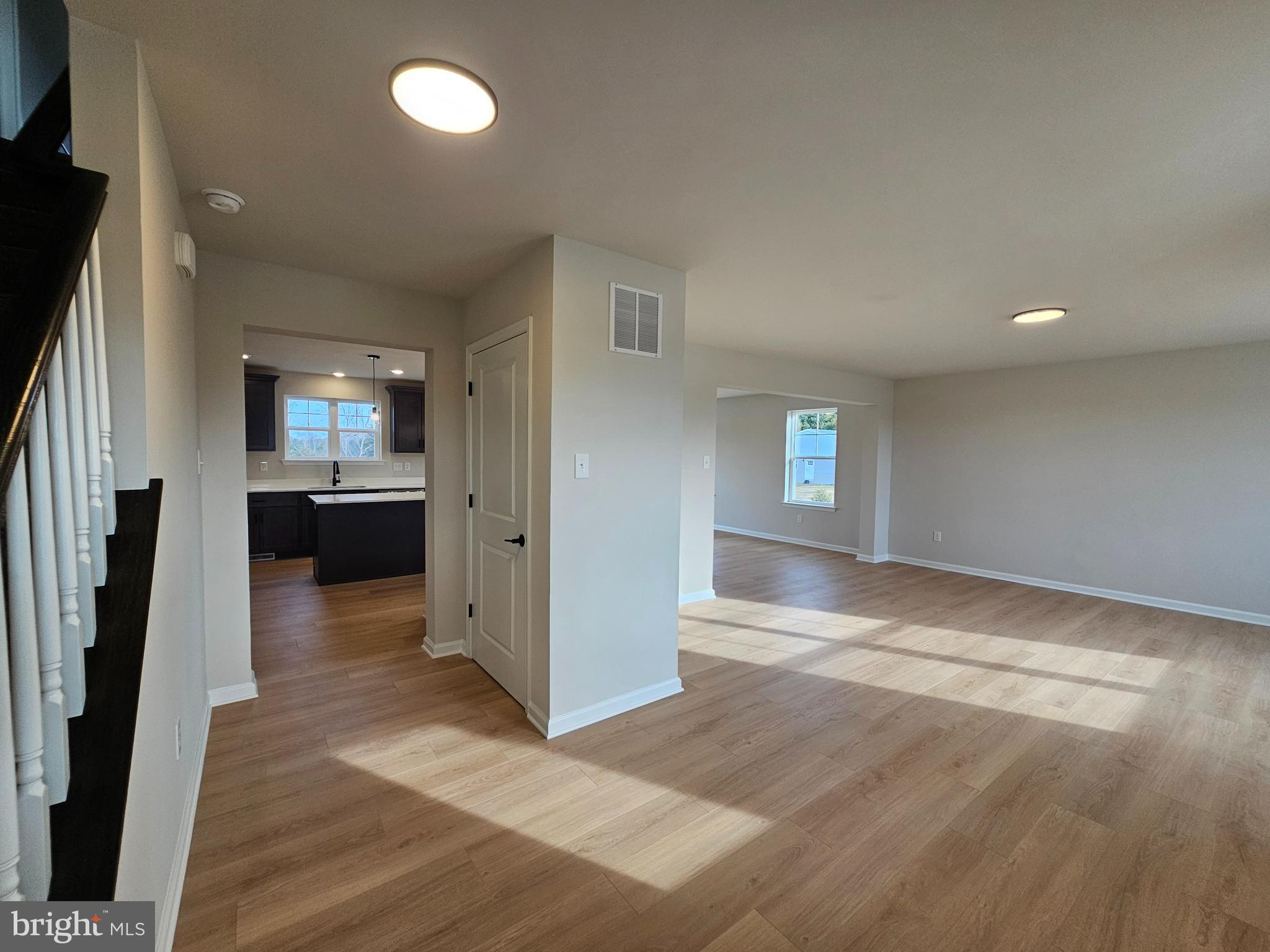16 Field Stone Court Bridgeton, NJ 08302 - Photo 12 of 20 an empty room with wooden floor and a kitchen