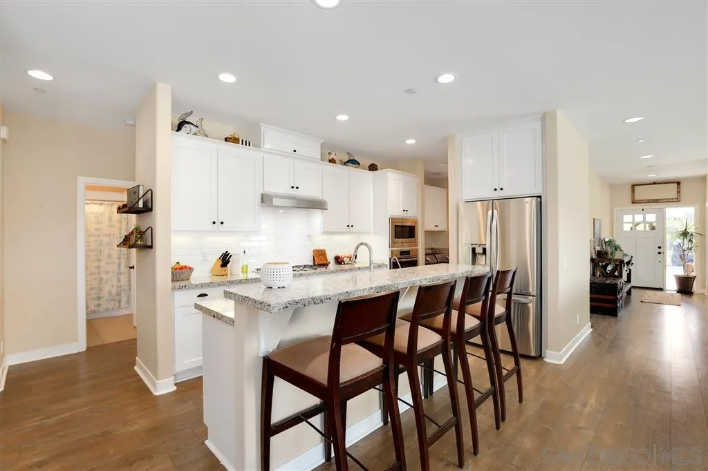 12972 Anthony Ridge Road Valley Center, CA 92082 - Photo 3 of 25 a kitchen with a dining table chairs refrigerator and cabinets