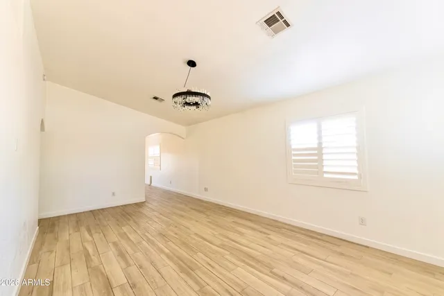 an empty room with a window and a ceiling fan