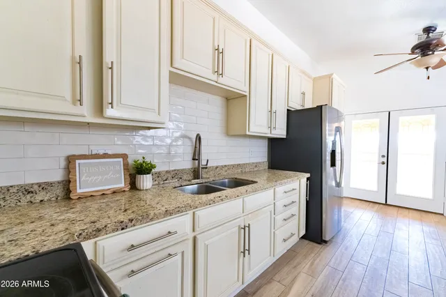 a kitchen with granite countertop cabinets stainless steel appliances a sink and wooden floor