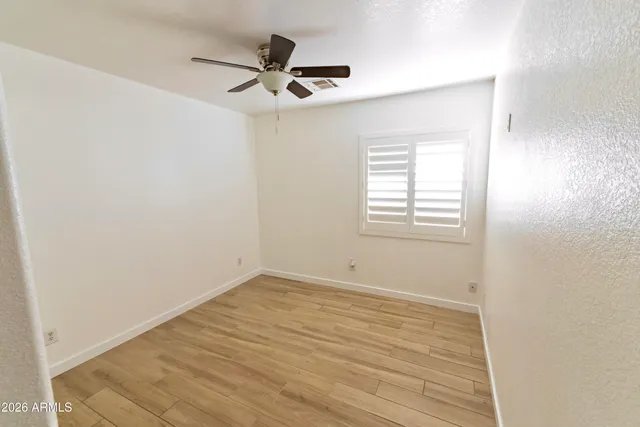a view of a room with wooden floor and a window