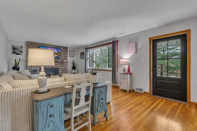 a living room with furniture a large window and wooden floor
