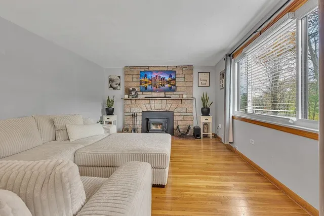 a living room with furniture a large window and a fireplace