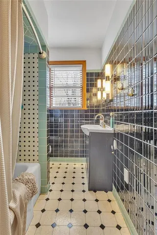 a bathroom with a sink a toilet a window and shower