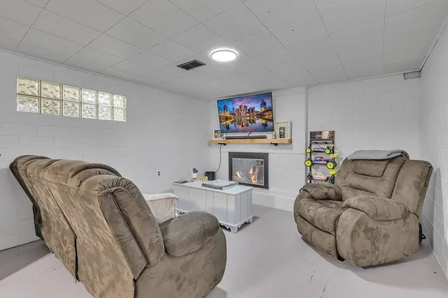 a living room with furniture a fireplace and a flat screen tv