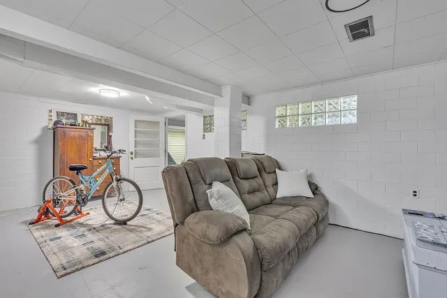 a living room with furniture a gym equipment and wooden floor