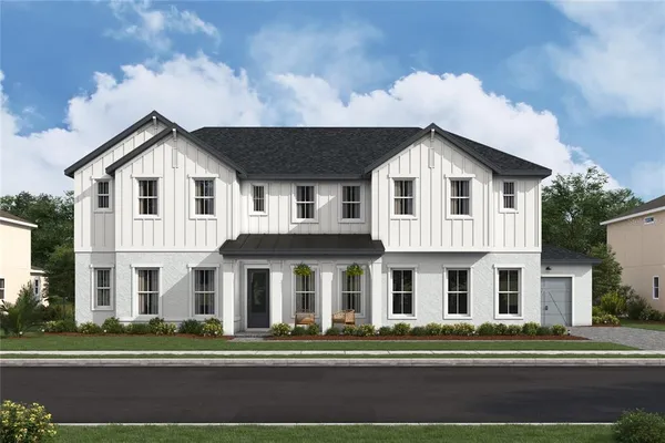 a white house with a large windows and a white building in front of it
