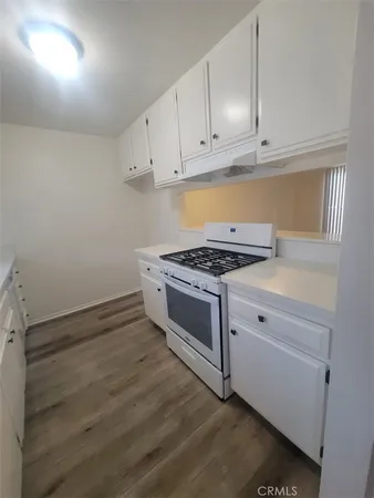 a kitchen with granite countertop white cabinets and white appliances