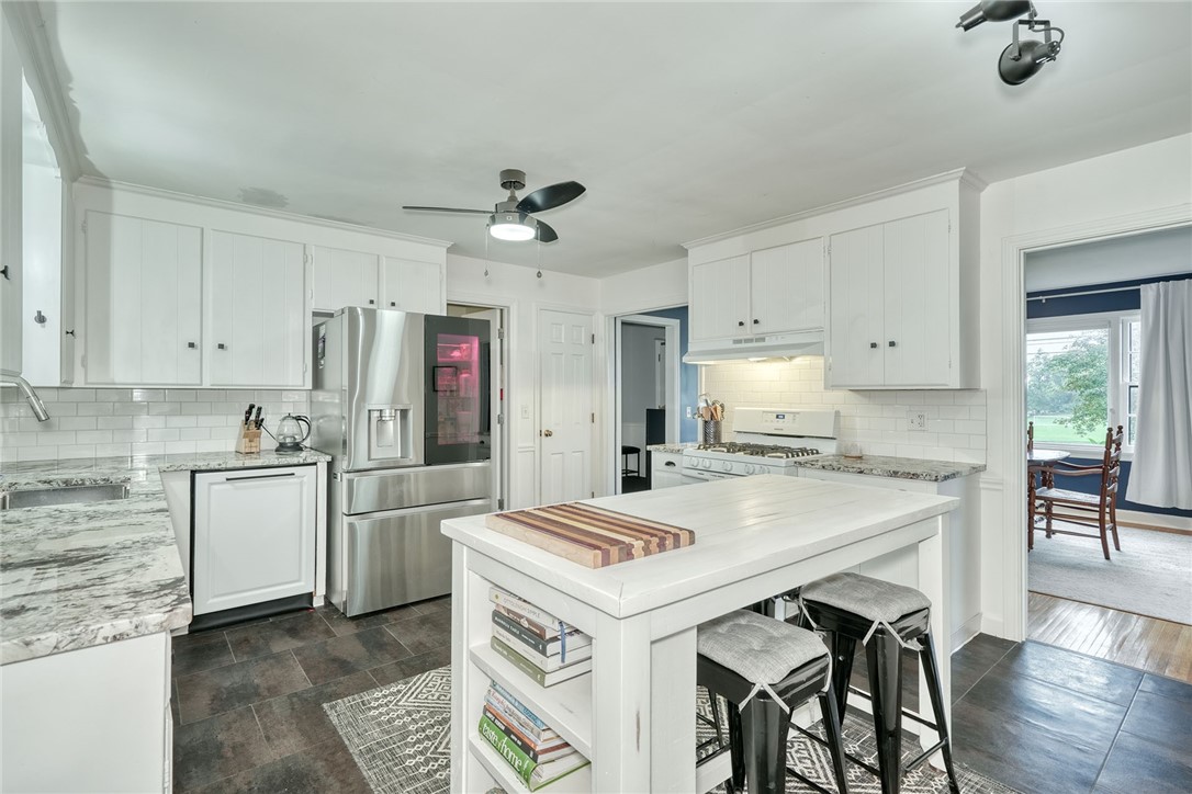 Gleaming stone countertops and a central workspace anchor this functional, well-appointed kitchen.