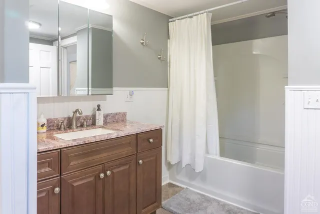 a bathroom with a granite countertop sink mirror and a bathtub