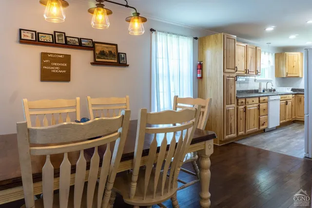 a kitchen with stainless steel appliances a dining table chairs and a refrigerator