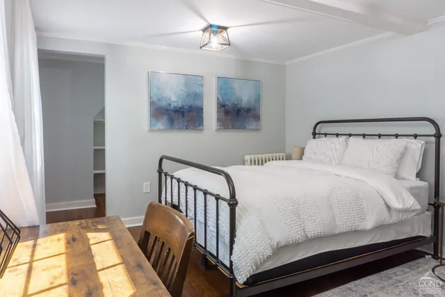 a bedroom with a bed and painting on the wall