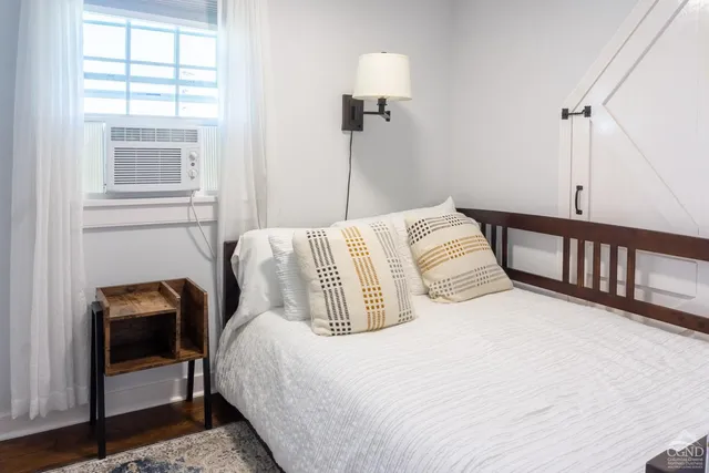 a bedroom with a bed and wooden floor