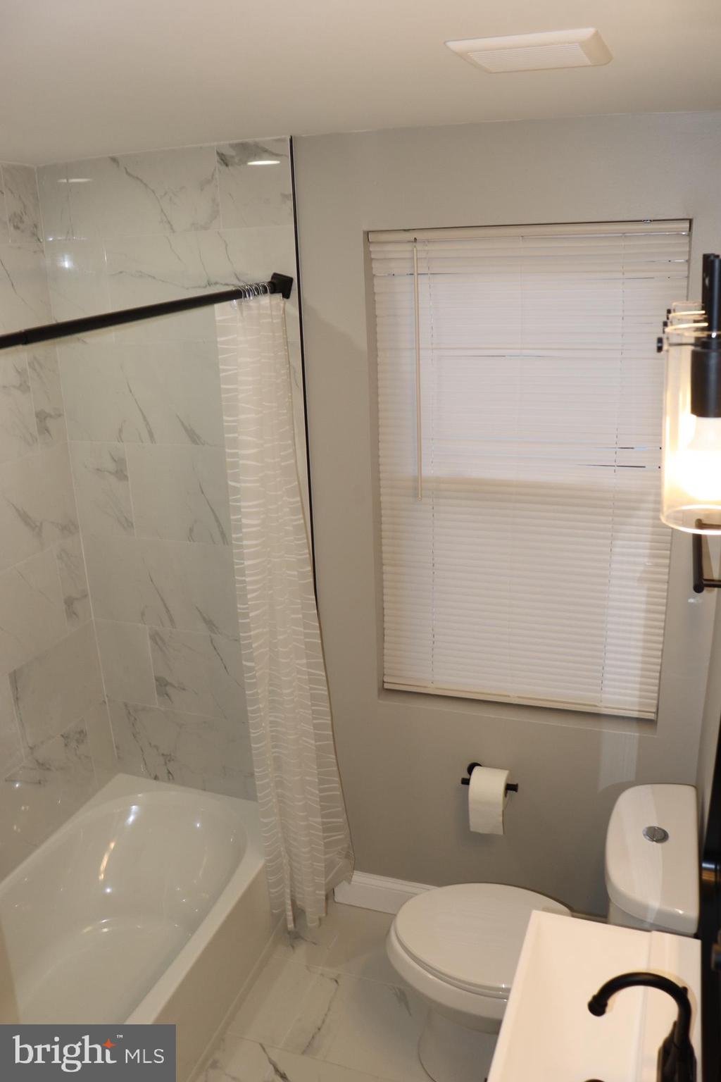 8623 Willow Oak Road Parkville, MD 21234 - Photo 13 of 27 a bathroom with a toilet and a bathtub