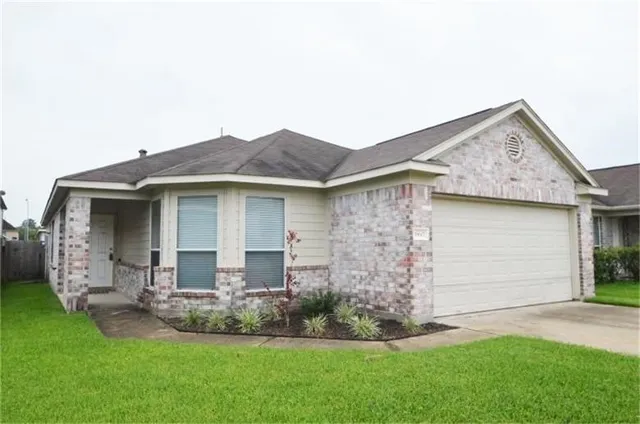 a front view of a house with a garden and yard