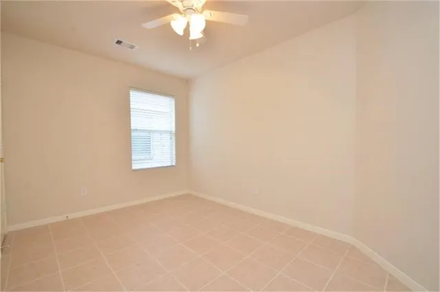 an empty room with a chandelier fan