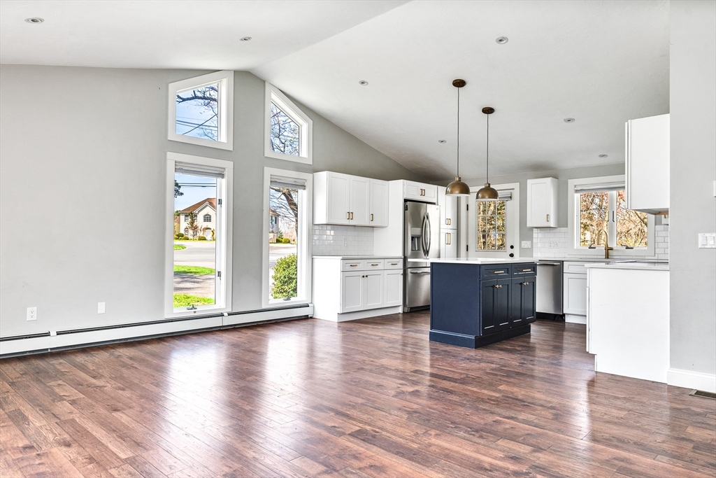 151 Wheeler Street Rehoboth, MA 02769 - Photo 10 of 36 a kitchen with stainless steel appliances kitchen island wooden floors and white cabinets