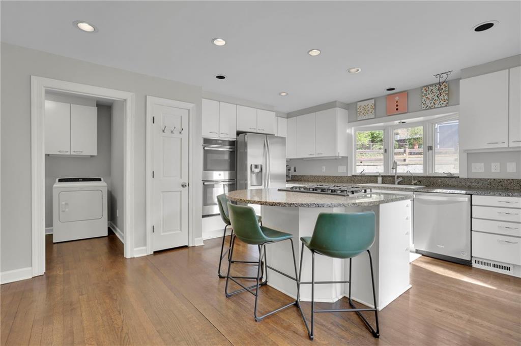 2476 Burnt Leaf Lane Decatur, GA 30033 - Photo 3 of 41 a kitchen with stainless steel appliances granite countertop a white cabinets and wooden floor