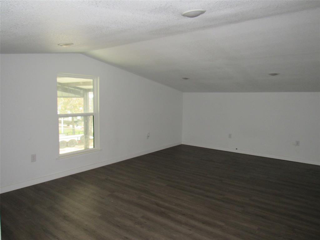 108 Private Road Whitney, TX 76692 - Photo 8 of 14 an empty room with wooden floor and window
