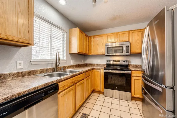 a kitchen with granite countertop a sink stainless steel appliances and cabinets