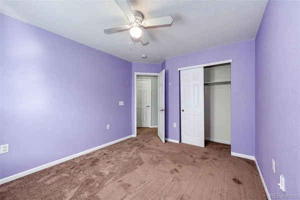 a view of a livingroom with a chandelier fan and a ceiling fan