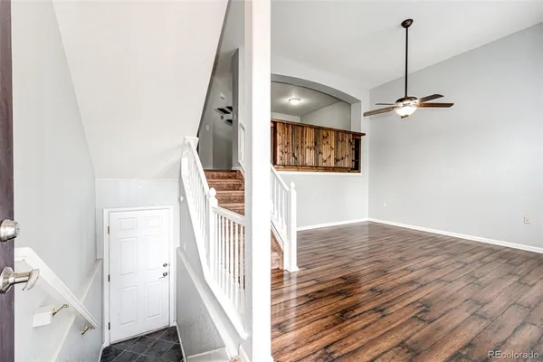 a view of a hallway with wooden floor and staircase